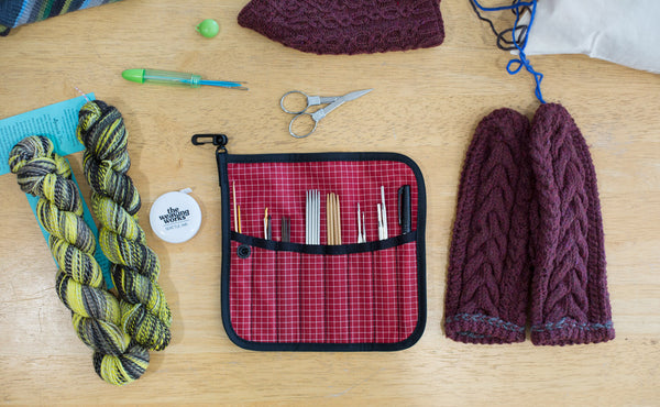 A Pen Tool Wrap filled with knitting needles, thread rippers, a pen, and a fine-tipped Sharpie.